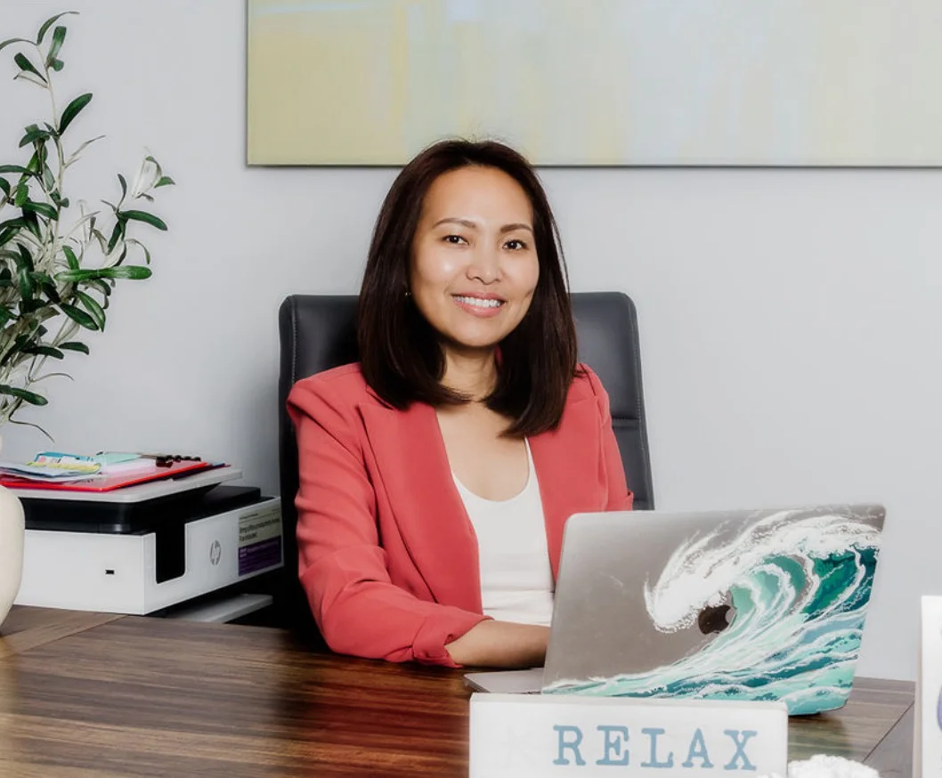 Healthcare provider at desk in clinical office with laptop and wellness décor